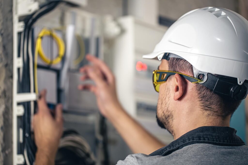 an electrician works on the electrical panel of a house