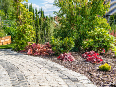 Beautiful Residential Backyard Garden with Granite Bricks Path. Summer Time Garden Scenery.