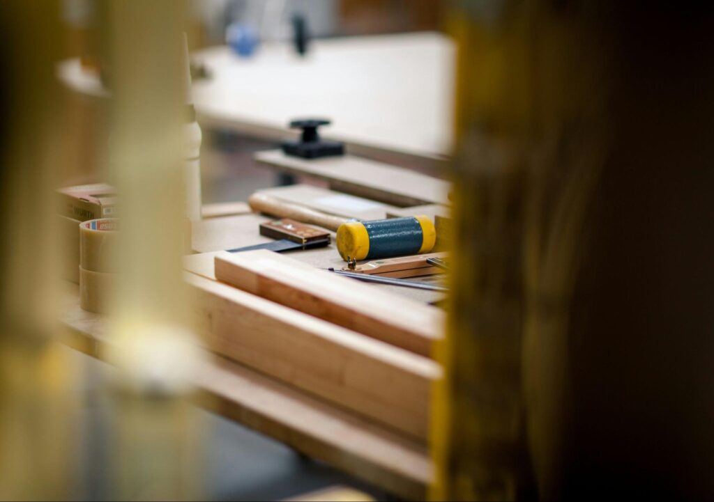 A carpenters workshop table with tools and pieces of wood on it.