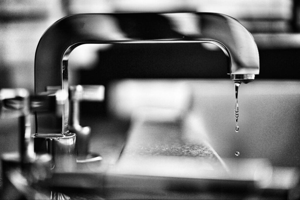 Black and white photo of a leaky faucet