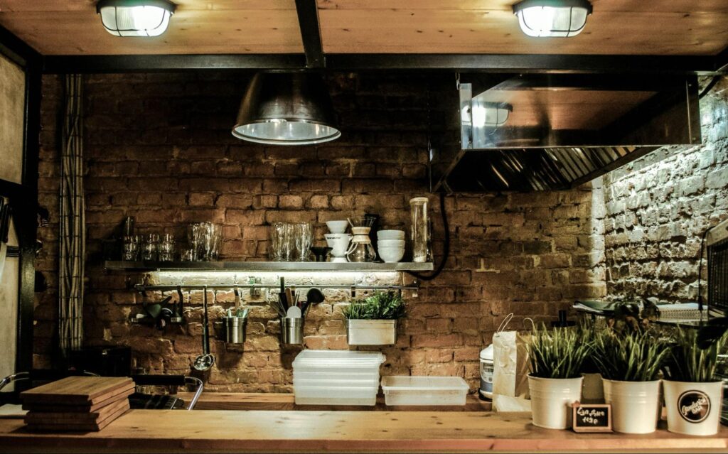 Industrial style kitchen with open shelving and stone walls