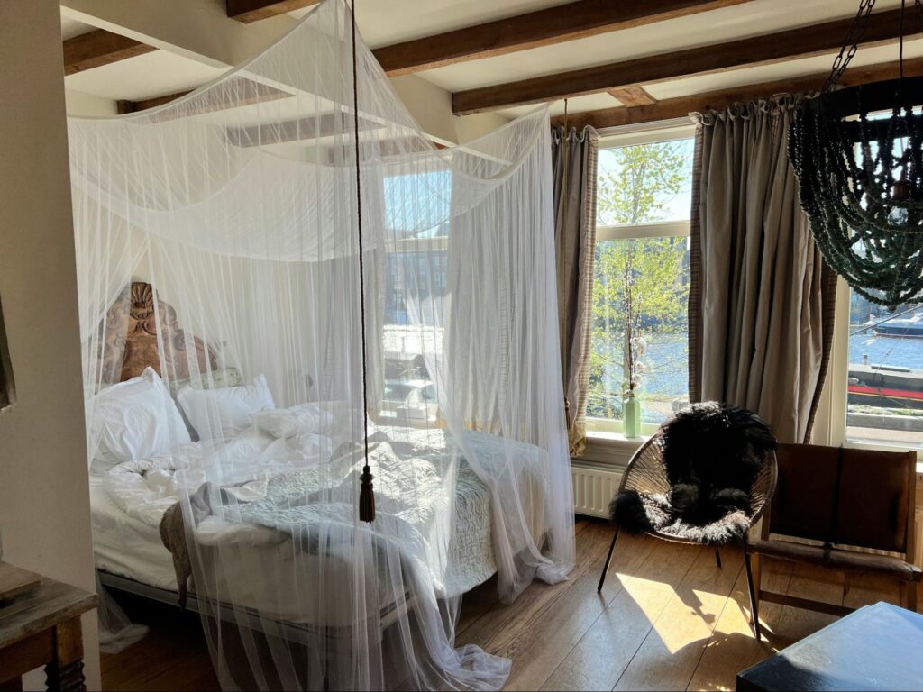 A big canopy bed with white curtains