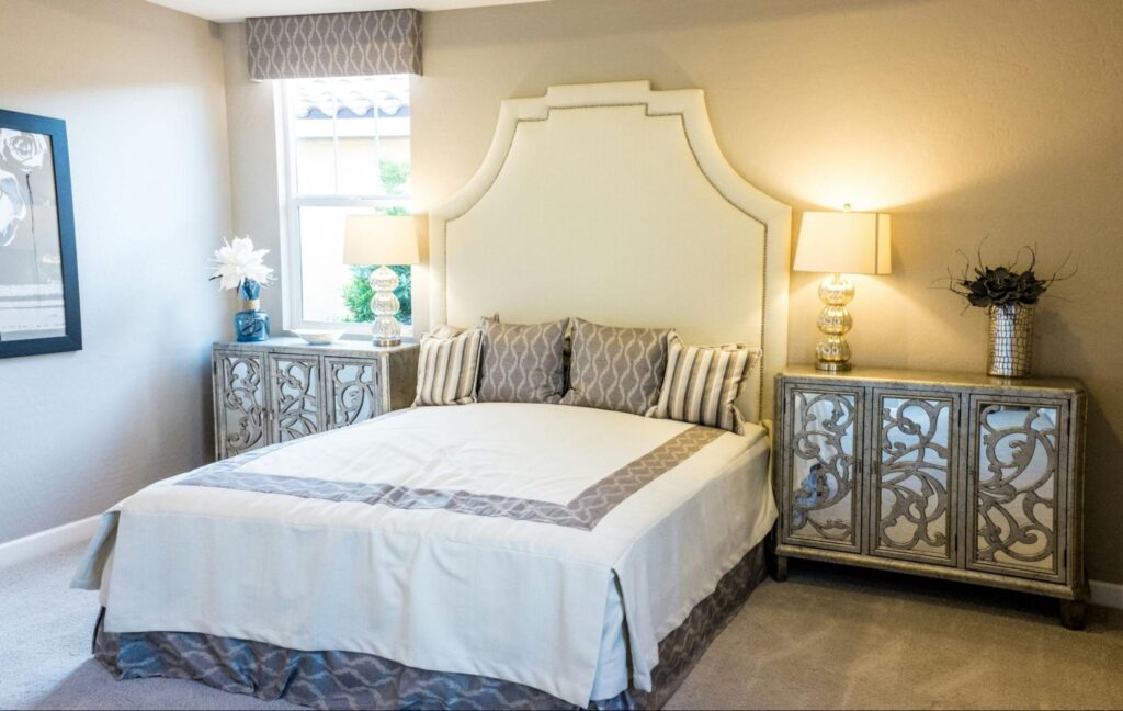 A master bedroom with large bed with an oversized headboard and nightstands