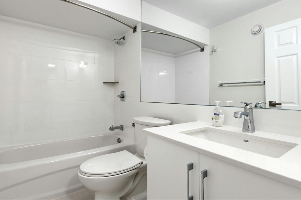 An all white bathroom with a bathtub, toilet and sink