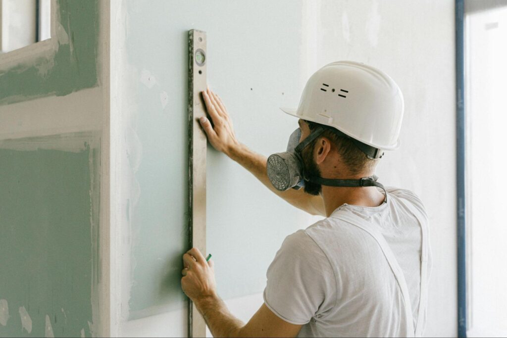 a handyman drylining a wall