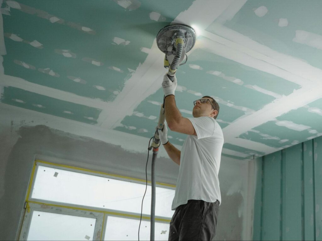 a handyman using a tool for the ceiling