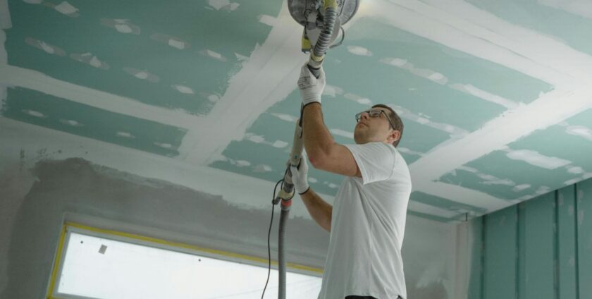 a handyman using a tool for the ceiling