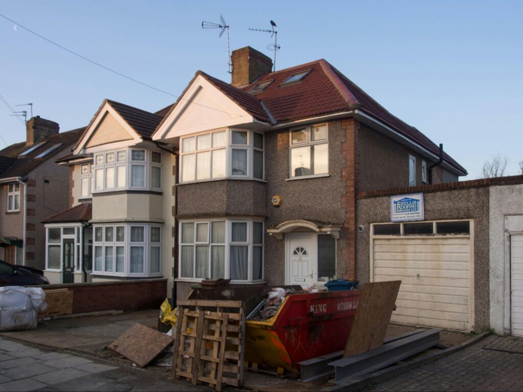 Residential homes with building trash in front 