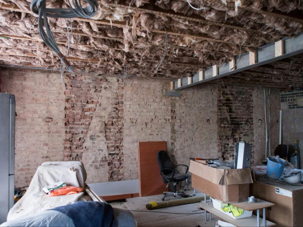 A room during renovation with building materials and boxes on the ground