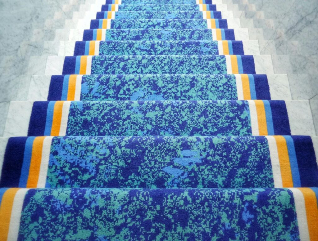 A blue staircase rug with stripes in both ends