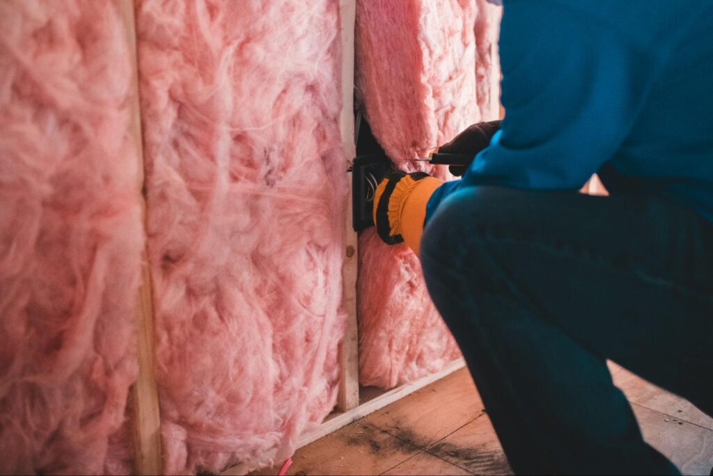 Construction worker insulating a wall