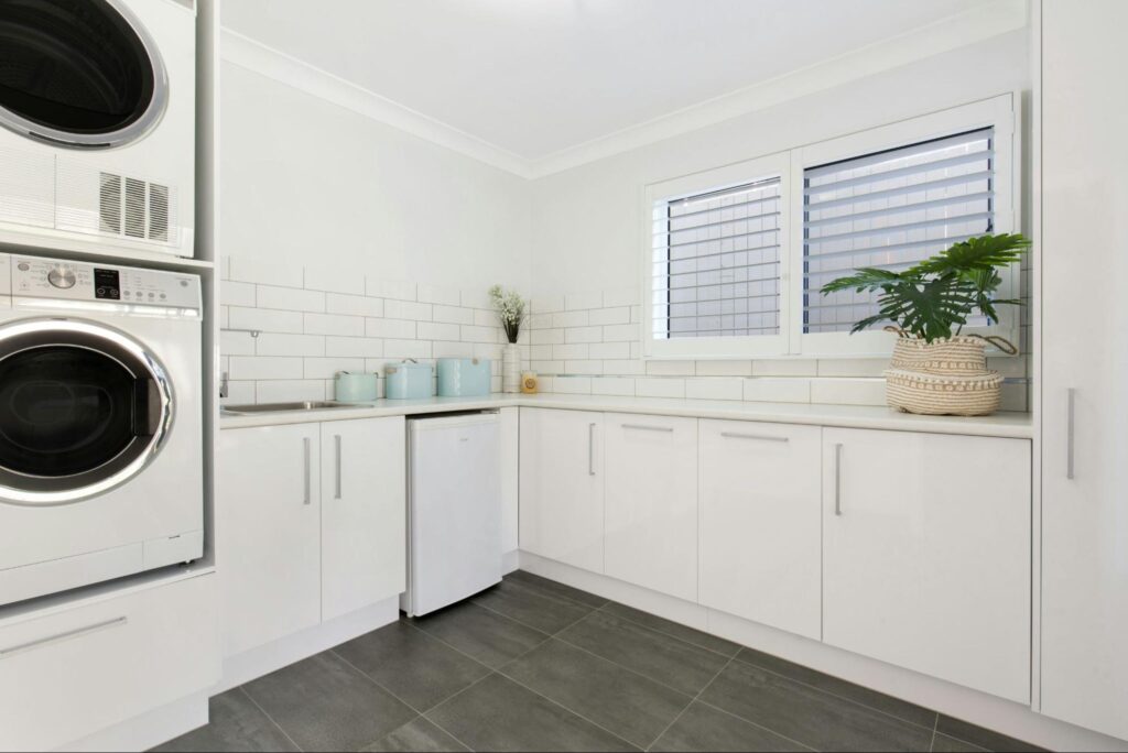 A white laundry room with a window
