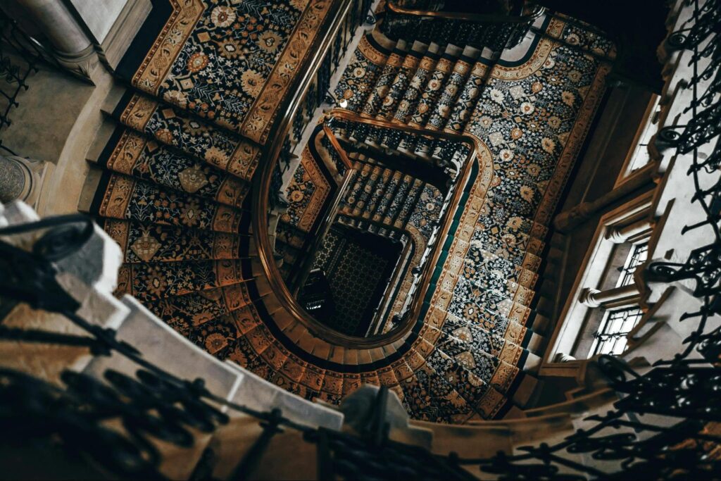 A spiral staircase with a patterned rug on it
