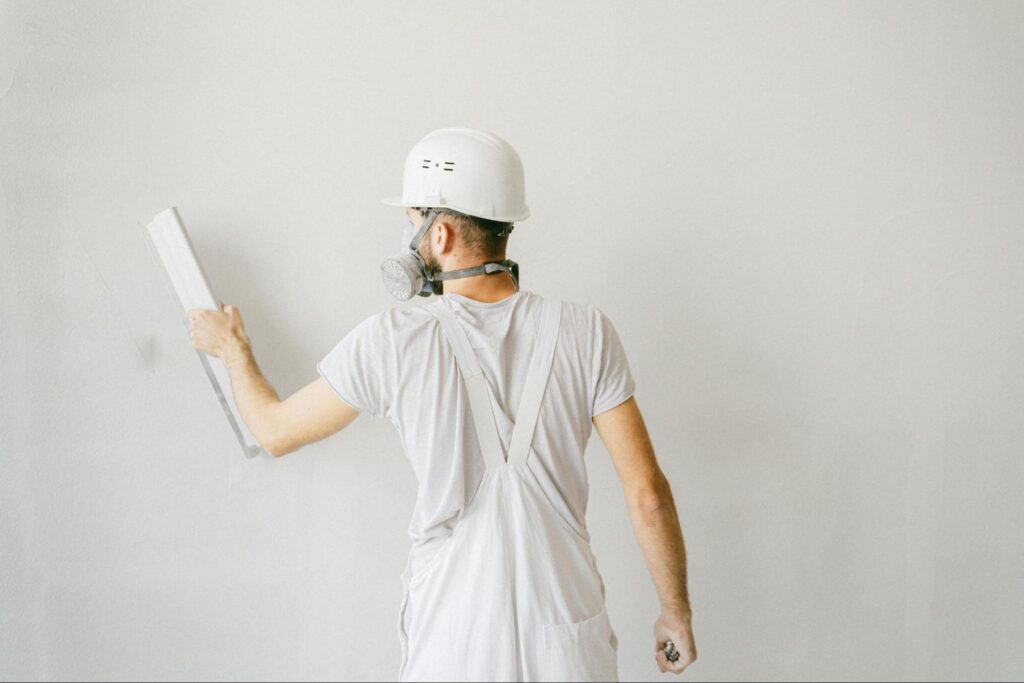 A man finishing off a plasterboard wall