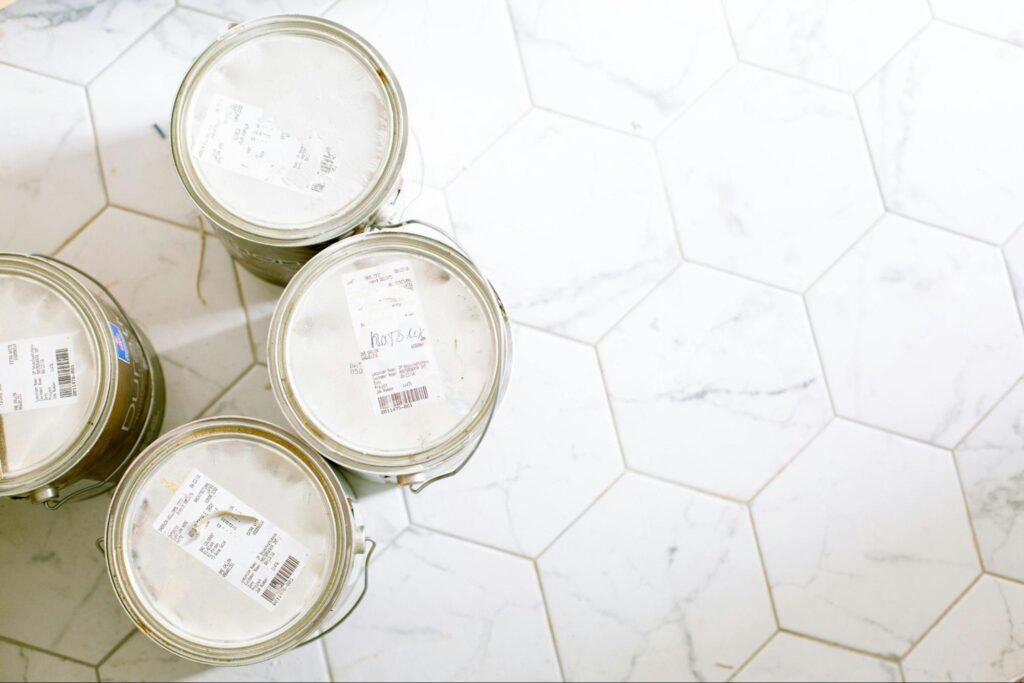 Buckets of paint on a tiled floor