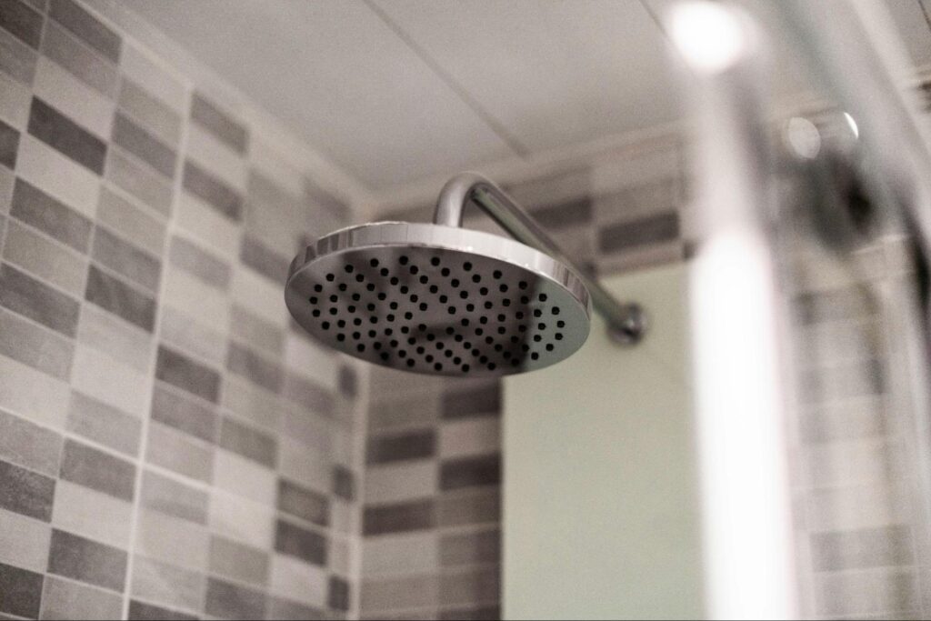 A big shower head in a black and white bathroom